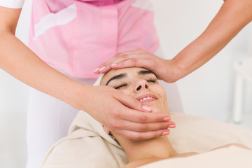 Fototapeta na wymiar Beautician doing massage of female faces. Massage face girl close-up.