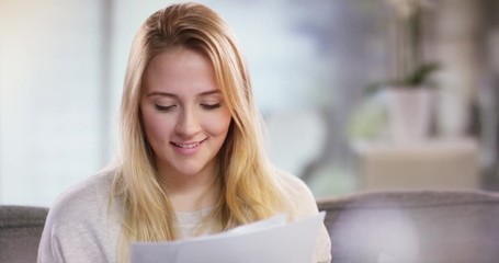 Portrait of a smiling young woman reading a letter
