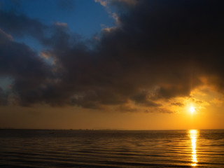 Fototapeta premium beautiful sunset over water and silhouette fishing boat