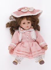 Old doll in a pink dress on a white background