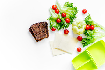 Preparing light vegetable lunch with tomatoes, salad, bread, paprica, cheese on white background top view copyspace