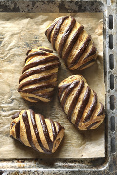 Freshly baked bicolor pain au chocolat on a baking tray.Top view