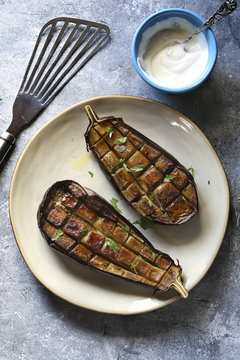 Roasted eggplant on a plate with garlic yogurt sauce .Top view