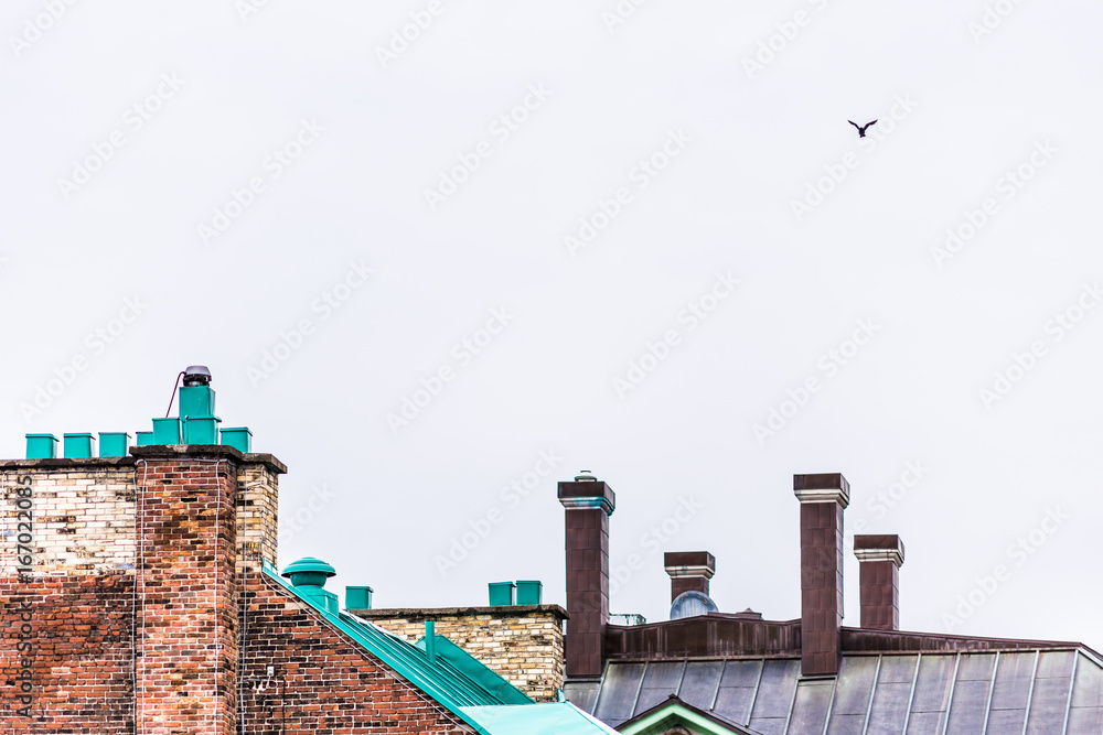 Wall mural cityscape of old town brick rooftops and bird flying on cloudy day in quebec city, canada