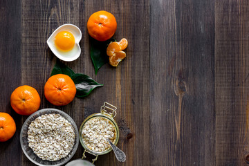 Sweet summer breakfast. Oatmeal, oranges, sugar on wooden table background top view copyspace