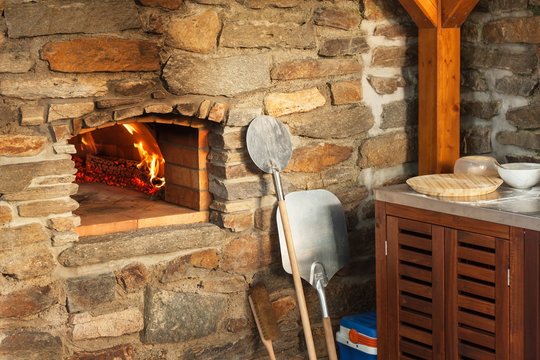 Home outdoor stone pizza oven. Traditional pizza production. Preparation of dinner.