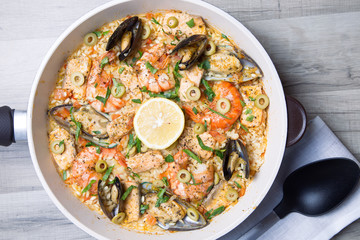 Paella with tiger shrimps, mussels, salmon and olives. Traditional Spanish dish.