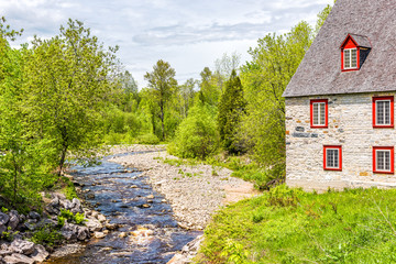 Fototapeta na wymiar Stone cottage colorful house by river on Chemin du Roy in Quebec, Canada