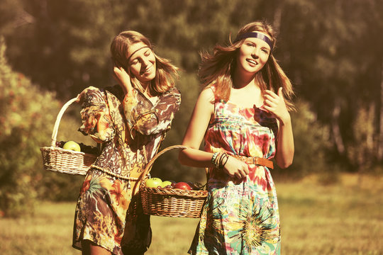 Happy young fashion girls with a fruit basket walking outdoor