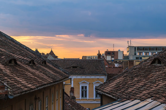 Architectural details and house roofs with attic windows designed in eyes shape in Sibiu city at sunset time, Romania