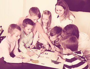 Children with teacher drawing together in classroom