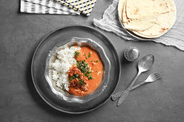 Plate with delicious Murgh Makhani and rice on table