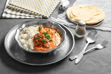Plate with delicious Murgh Makhani and rice on table