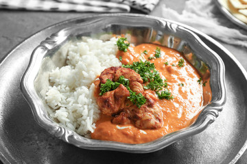 Plate with delicious Murgh Makhani and rice on table