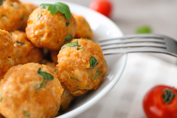 Bowl with delicious turkey meatballs on table, closeup