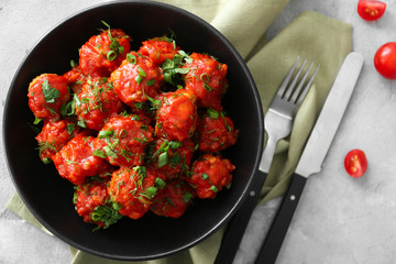 Plate with delicious turkey meatballs and tomato sauce on table