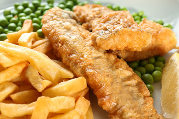 Tasty fried fish and chips on plate, closeup