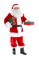 Happy authentic Santa Claus holding gift boxes on white background