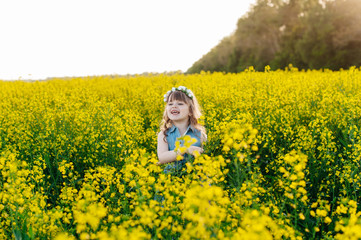 A young girl walks the yellow field