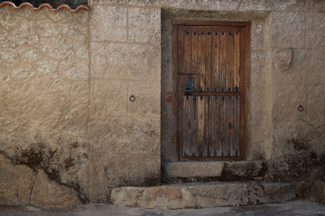 Fototapeta na wymiar Puerta de madera antigua sobre pared de piedra