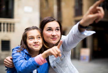 Mother and daughter pointing at sight during