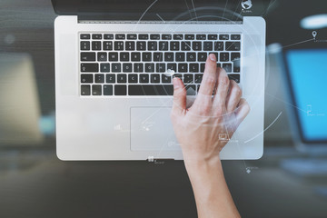 top view of businessman typing keyboard with laptop computer on wooden desk in modern office with virtual reality icon diagram