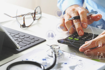 Healthcare costs and fees concept.Hand of smart doctor used a calculator for medical costs in modern hospital