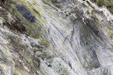 Fototapeta na wymiar An abstract close up of mineral veins running through green rock in a textured background.