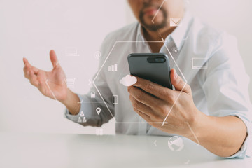 Big data analytics with business intelligence (BI) concept. businessman using mobile phone and laptop computer on white desk