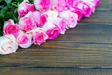 Wooden background with pink roses. A place for congratulations. Concept Happy Birthday, March 8, Mother's Day.