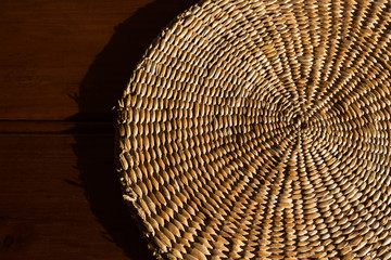 Fototapeta premium An abstract close up background of a hand woven, spiral, textured wicker grass mat.