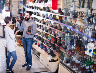 Fototapeta na wymiar Couple choosing sneakers in store