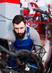 Fototapeta na wymiar Worker repairing motorbike