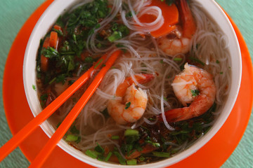 vietnamese soup pho with shrimps and sea food close up photo with table spoon
