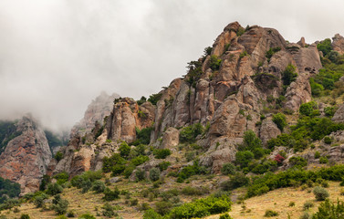 Clouds passing below the top of the mountain. Rocks of unusual shape