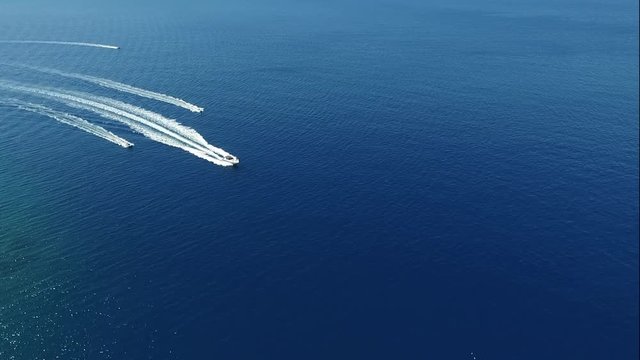 Drei Motorboote fahren nebeneinander auf dem Meer