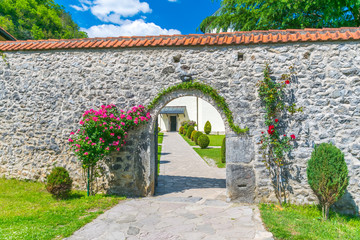 The entrance to the monastery of Moraca is decorated with flowers and plants. Montenegro.
