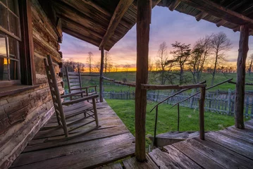Fototapete old worn porch with rocking chairs at sunset, appalachian mountains © aheflin