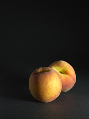 Two Peaches on black background
