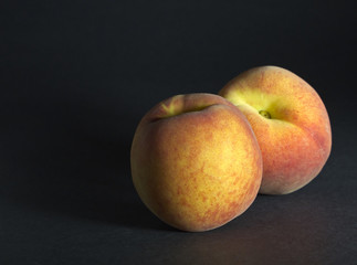 Two Peaches on black background