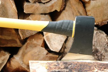 Modern Axe Stuck in Log in Front on Wood Pile 