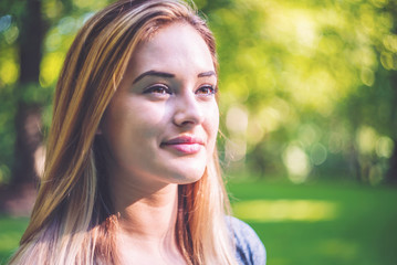 Naklejka premium Portrait of a happy young woman outside on a bright summer day