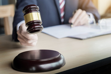 Male Judge In A Courtroom Striking The Gavel on sounding block