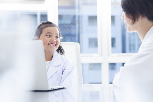 The teacher and the girl are studying with a laptop computer - Powered by Adobe