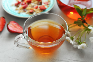 Glass cup of tea served for breakfast on table