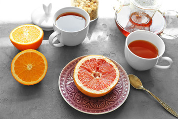 Cups of tea and fruits served for breakfast on table