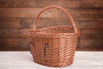 Fototapeta na wymiar Bicycle wicker basket on wooden table