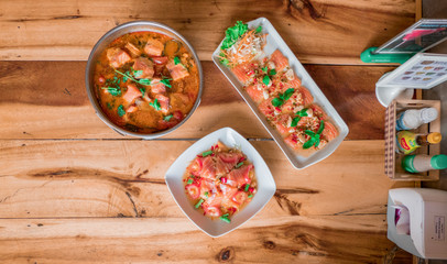 Salmon spicy salad and salmon tomyam, Top view to wood table
