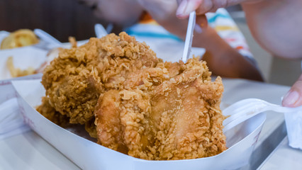 Close up hand eating Fried chicken in fast food shop