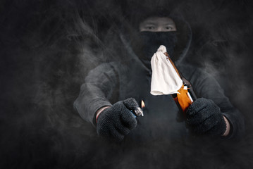 Protester or terrorist with Molotov cocktail as known as petrol bomb or bottle bomb with smoke...